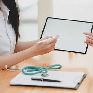 Woman showing tablet to patient