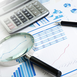 Set of graphics and financial charts with calculator and magnifying glass on top